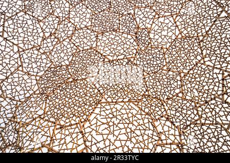 Wooden wall made from sticks which connected randomly in geometry shapes. Stock Photo