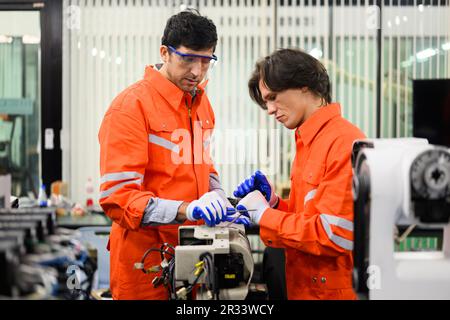 Engineers working and solving problems on machine at industrial plant Stock Photo
