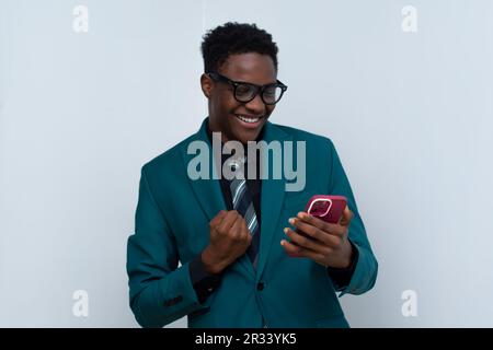 young african businessman wearing a suit and using his phone Stock Photo