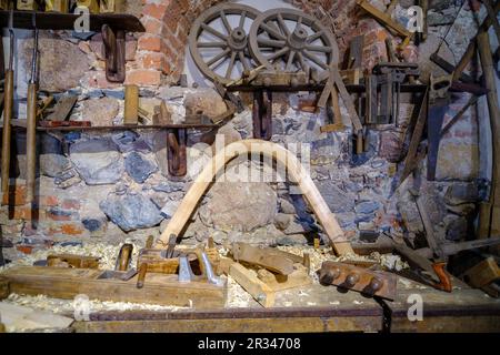 Carpenters tools background. Old-fashioned rusty carpenter's tools, various tools on the table. a wooden horse cart on the wall. Stock Photo