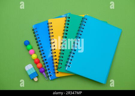 Collection different bright school stationery and notebooks on green background, flat lay. Back to school concept. Stock Photo
