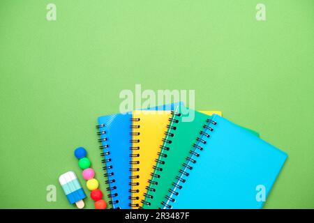 Collection different bright school stationery and notebooks on green background, flat lay. Back to school concept. Stock Photo