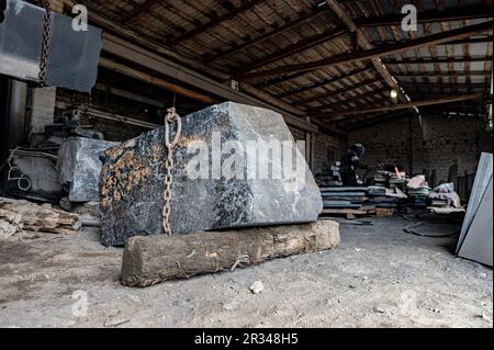 Huge granite stone in a stone processing factory. Stone cutting Stock Photo