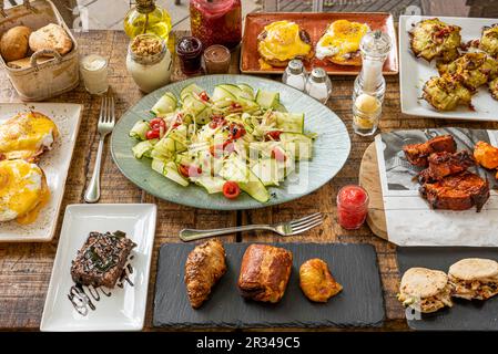 Set of typical brunch dishes with sweets, salads, eggs Benedict, yogurts and jams Stock Photo