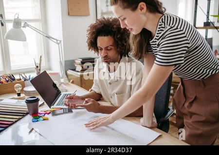 Young colleagues working together in startup company. Stock Photo