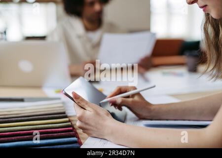 Close up of young colleagues working in designers studio. Stock Photo