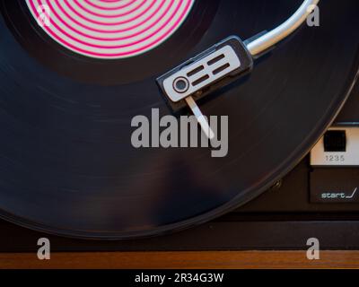Detail of a needle on a track of a black vinyl record. Vintage turntable. Stock Photo