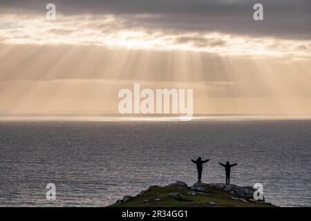 niños jugando al atardecer, Neist Point, isla de Skye, Highlands, Escocia, Reino Unido. Stock Photo