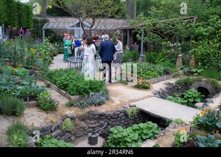 Chelsea, London, UK. 22nd May, 2023. The Savills Garden designed by Mark Gregory at the RHS Chelsea Flower Show. The garden evokes the experience of an intimate walled garden of an imagined country hotel, featuring a contemporary seasonal potager that offers both a sanctuary and a source of the very best in flavours. Credit: Maureen McLean/Alamy Live News Stock Photo