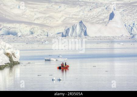 A group of tourists makes an excursion on a motorboat in Antarctica. Stock Photo