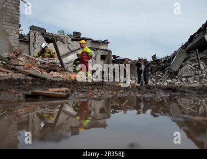 Dnipro, Ukraine. 21st May, 2023. Emergency response crews and police are reflected in a puddle near the site where a Russian Missile impacted and heavily damaged the Emergency Services Base of Dnipro the night before. On the night of May 21st, 12 missiles including Iskander-M ballistic Missiles, s-300 missiles, and others landed in Dnipro, Ukraine damaging the Emergency Service Base in Dnipro destroying emergency vehicles and equipment, and other buildings in the area. Credit: SOPA Images Limited/Alamy Live News Stock Photo