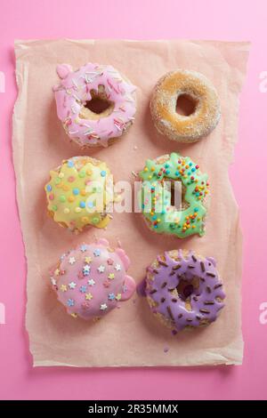 Doughnuts with glaze on a pink surface Stock Photo