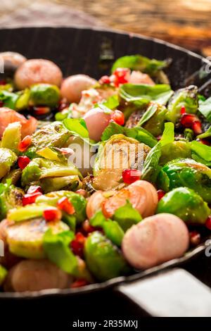 Fried Brussels sprouts with basil, onions and pomegranate seeds Stock Photo