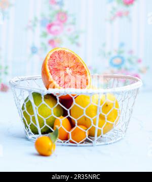 Various citrus fruit in a wire basket Stock Photo