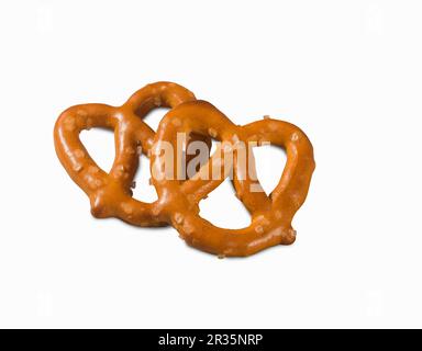 Two mini salted pretzels on a white surface (close-up) Stock Photo