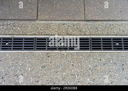 Metal landscape trench rain water drain system in a public area Stock Photo