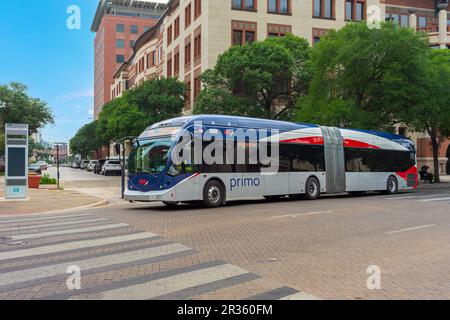 San Antonio, Texas, USA – May 8, 2023: A VIA Metropolitan Transit articulated bus traveling in downtown on Dolorosa Street in San Antonio, Texas. Stock Photo