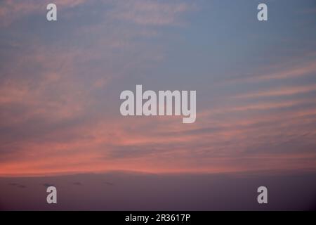 The beautiful reds and oranges of the sunsetting reflecting off clouds Stock Photo