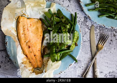 Fish baked in paper with beans and mange tout Stock Photo