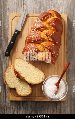 Sliced brioche with sugar nibs on a wooden board (seen from above) Stock Photo