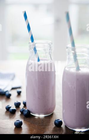 Two bottles of blueberry and banana smoothie with straws Stock Photo
