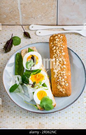 An open egg sandwich with mange tout Stock Photo