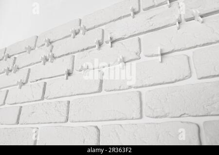 Decorative white bricks with tile leveling system on wall Stock Photo