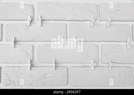 Decorative white bricks with tile leveling system on wall Stock Photo