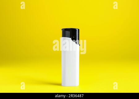 Stylish small pocket lighter on yellow background Stock Photo