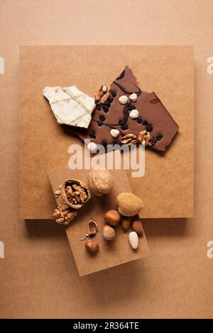 Chocolates and a nut mixture consisting of almonds, walnuts and hazelnuts on a cardboard box Stock Photo