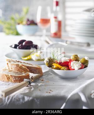 Various types of antipasti with bread and olives on a laid table Stock Photo