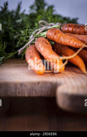 Fresh carrots on a wooden chopping board Stock Photo