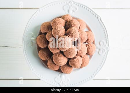 A pile of chocolate pralines on a white plate Stock Photo