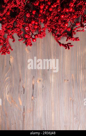 Holly berry twigs on wood wall Stock Photo