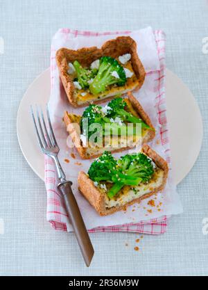 Broccoli and sheep's cheese quiche cut into slices Stock Photo