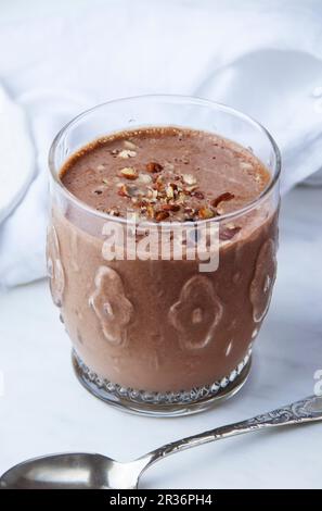 A high-protein chocolate & almond smoothie in a glass, topped with chopped nuts Stock Photo
