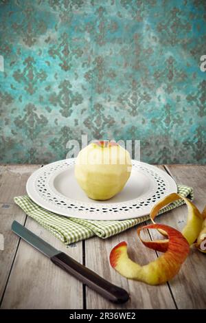 A peeled apple on a plate Stock Photo