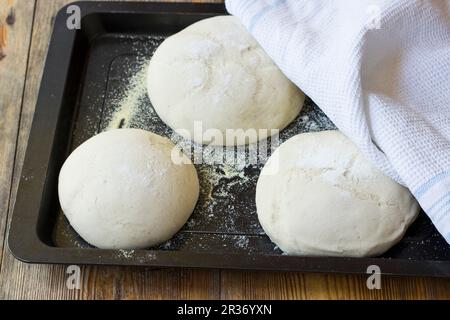 Pizza dough on a baking tay Stock Photo