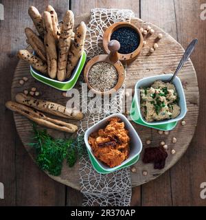 Vegan herb hummus and tomato hummus with sesame sticks Stock Photo