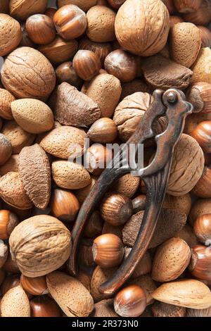 Various nuts and a vintage nutcracker Stock Photo