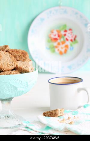 A bowl of gluten-free biscuits with buckwheat flour and coconut blossom sugar, and coffee in an enamel cup Stock Photo