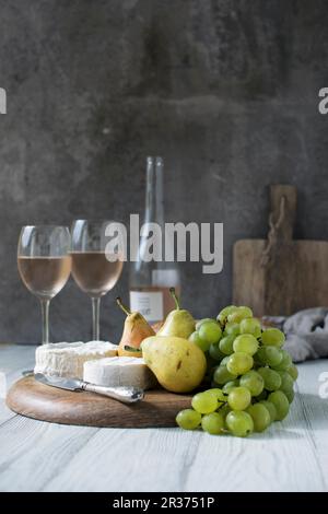 An arrangement of cheese, pears, grapes and rosé wine Stock Photo