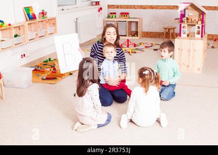 Teacher teaches preschoolers Stock Photo
