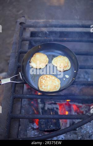 Pancakes in a pan on a fire grate Stock Photo