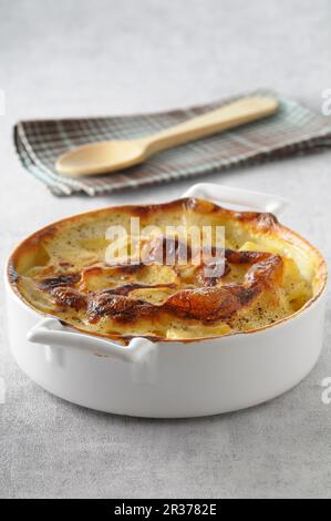 Potato gratin in a round baking dish Stock Photo
