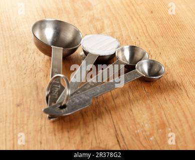 https://l450v.alamy.com/450v/2r378g2/four-measuring-spoons-one-showing-a-level-teaspoon-of-baking-powder-shot-on-a-wooden-surface-2r378g2.jpg