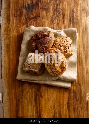 Fresh bread rolls on a folded kitchen towel Stock Photo