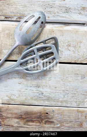 Three old metal spatulas on a wooden background Stock Photo
