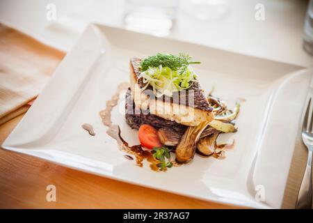 Dorade fillet on black rice with spring onions in a balsamic sauce Stock Photo