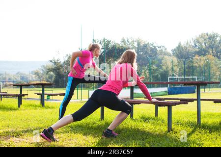 Two women doing stretching exercise Stock Photo